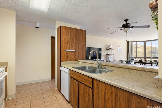 5070 Likini St Unit 1409, Honolulu, HI 96818 - kitchen with white dishwasher, light countertops, a sink, a ceiling fan, and brown cabinetry