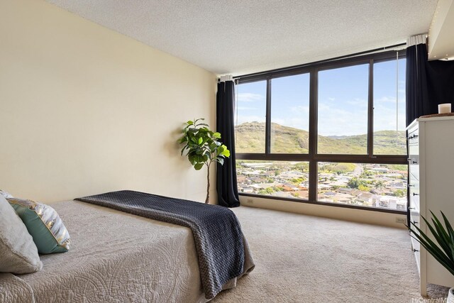 5070 Likini St Unit 1409, Honolulu, HI 96818 - bedroom with expansive windows, carpet floors, a textured ceiling, and a mountain view