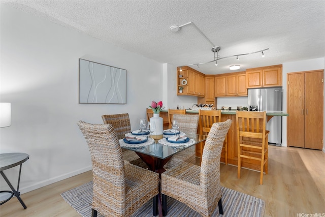 3138 Waialae Ave Unit 521, Honolulu, HI 96816 - dining area with light wood-type flooring, a textured ceiling, and baseboards