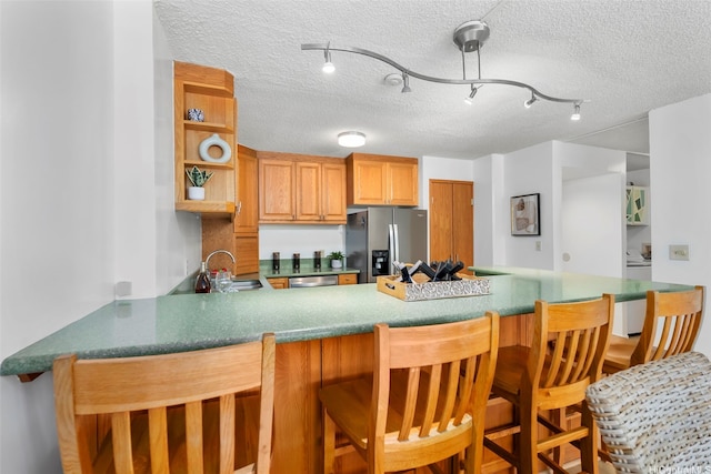 3138 Waialae Ave Unit 521, Honolulu, HI 96816 - kitchen with stainless steel appliances, a peninsula, a sink, a textured ceiling, and open shelves