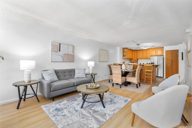 3138 Waialae Ave Unit 521, Honolulu, HI 96816 - living area featuring a textured ceiling, light wood finished floors, baseboards, and rail lighting