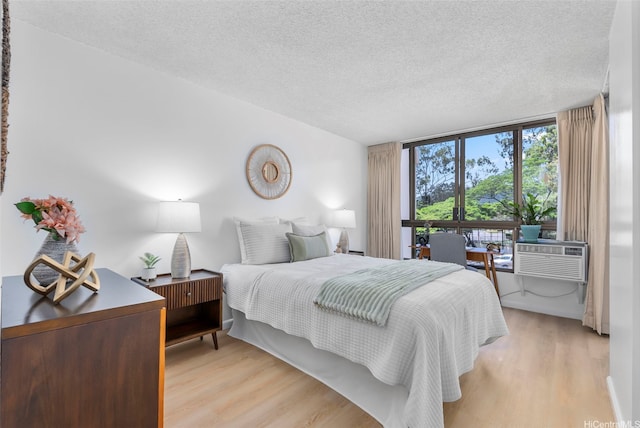 3138 Waialae Ave Unit 521, Honolulu, HI 96816 - bedroom with light wood-style floors, a textured ceiling, and cooling unit