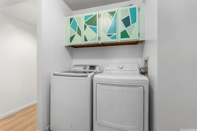 3138 Waialae Ave Unit 521, Honolulu, HI 96816 - laundry room with washer and dryer, wood finished floors, cabinet space, and baseboards