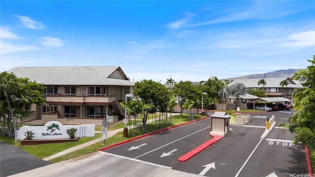 91-925 Puahala St Unit 44B, Ewa Beach, HI 96706 - view of asphalt road with street lights, curbs, a mountain view, a gated entry, and stairway
