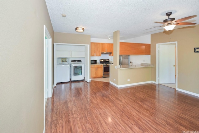 91-925 Puahala St Unit 44B, Ewa Beach, HI 96706 - kitchen featuring stainless steel gas range oven, a textured ceiling, black microwave, wood finished floors, and under cabinet range hood