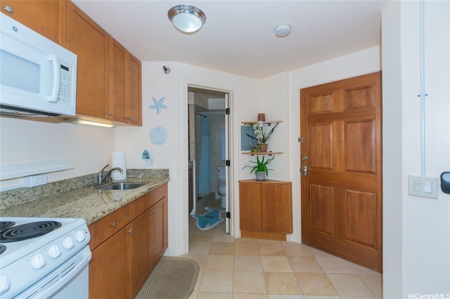 1700 Ala Moana Blvd Unit 1601, Honolulu, HI 96815 - kitchen featuring white microwave, a sink, light stone counters, brown cabinets, and light tile patterned floors