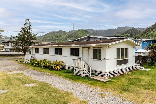 54-011 Waikulama St, Hauula, HI 96717 - view of front of property featuring a mountain view, a front lawn, and entry steps