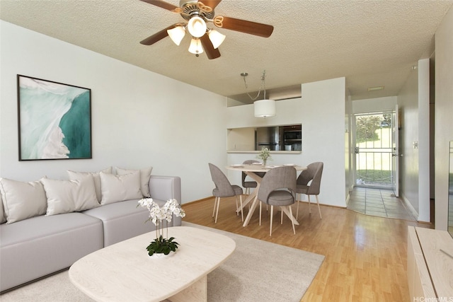 92-1045 Lalahi St Unit 102, Kapolei, HI 96707 - living area with wood finished floors, a textured ceiling, ceiling fan, and baseboards