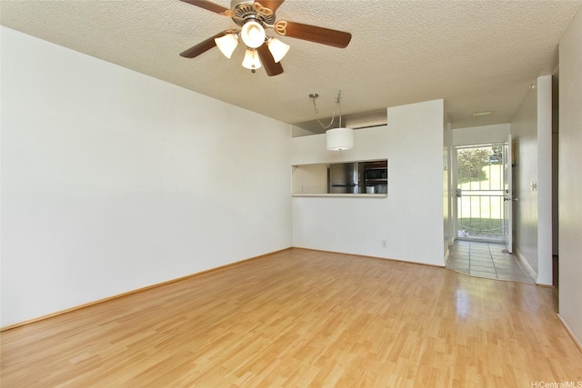 92-1045 Lalahi St Unit 102, Kapolei, HI 96707 - unfurnished room with wood finished floors, a textured ceiling, a ceiling fan, and baseboards