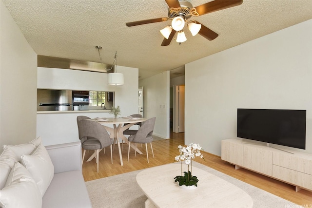 92-1045 Lalahi St Unit 102, Kapolei, HI 96707 - living area with a textured ceiling, wood finished floors, and a ceiling fan