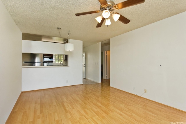 92-1045 Lalahi St Unit 102, Kapolei, HI 96707 - unfurnished living room featuring wood finished floors, a textured ceiling, a sink, and a ceiling fan