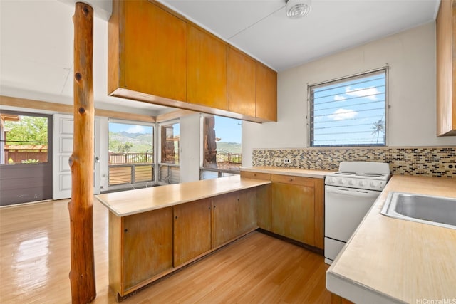 748 Ocean View Dr, Honolulu, HI 96816 - kitchen featuring white range, light countertops, light wood-style floors, backsplash, and a peninsula