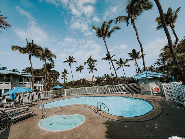 community pool with fence and a patio
