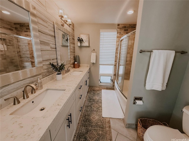 bathroom with toilet, tile patterned flooring, double vanity, baseboards, and backsplash