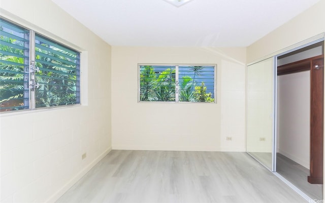 1611 Miller St Unit 303, Honolulu, HI 96813 - unfurnished bedroom featuring light wood-style flooring, multiple windows, a closet, and concrete block wall