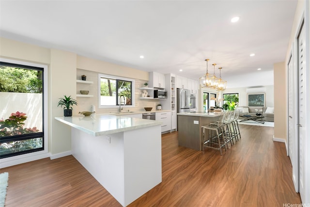 3002 Diamond Head Rd, Honolulu, HI 96815 - kitchen with open shelves, stainless steel appliances, a kitchen bar, a sink, and white cabinets