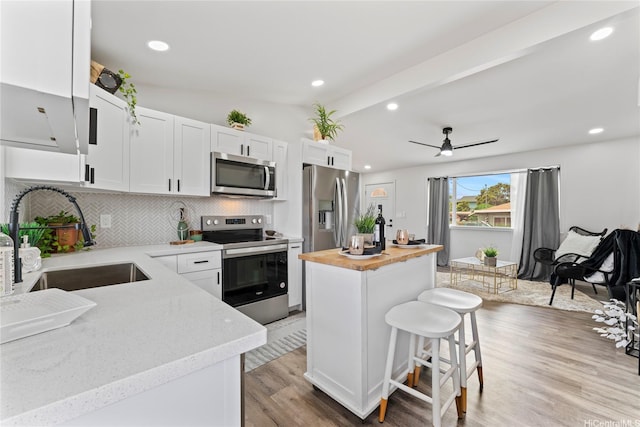 87-888 Waapuhi St, Waianae, HI 96792 - kitchen featuring appliances with stainless steel finishes, a sink, butcher block counters, lofted ceiling, and a kitchen island