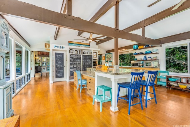 1149 Maunawili Rd, Kailua, HI 96734 - kitchen with a ceiling fan, light wood finished floors, a breakfast bar area, light stone countertops, and a center island