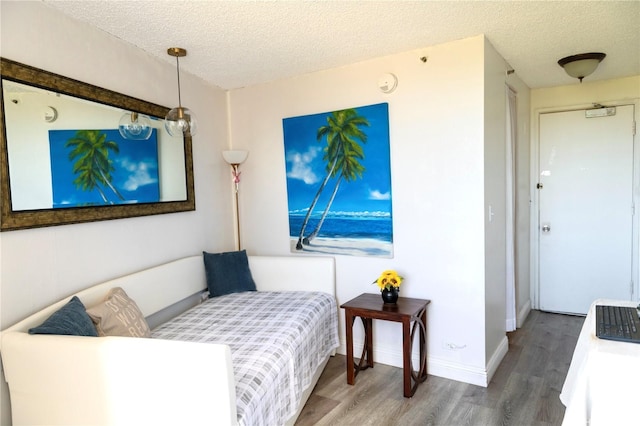 134 Kapahulu Ave Unit 707, Honolulu, HI 96815 - bedroom featuring wood finished floors, a textured ceiling, and baseboards