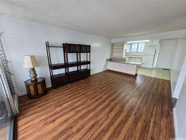 910 Kapahulu Ave Unit 303, Honolulu, HI 96816 - unfurnished living room with wood finished floors, a textured ceiling, and baseboards