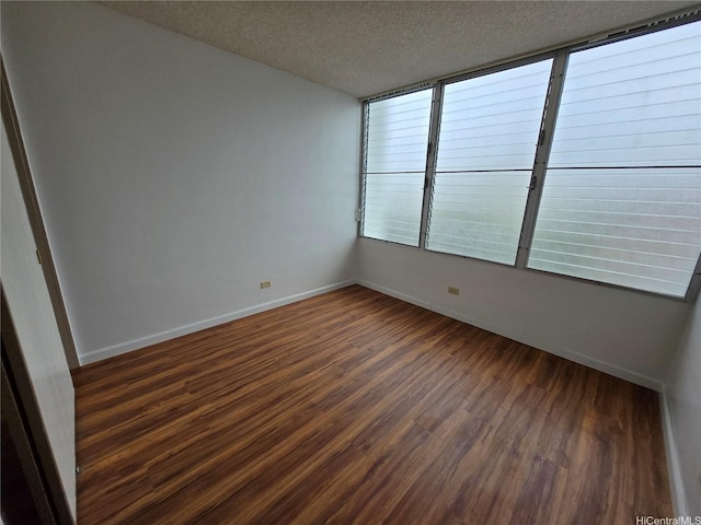 910 Kapahulu Ave Unit 303, Honolulu, HI 96816 - unfurnished room featuring dark wood-style floors, a textured ceiling, and baseboards