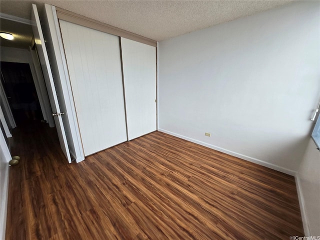 910 Kapahulu Ave Unit 303, Honolulu, HI 96816 - unfurnished bedroom with dark wood finished floors, a closet, a textured ceiling, and baseboards