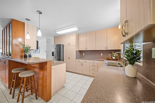 94-860 Kuhaulua St, Waipahu, HI 96797 - kitchen with stainless steel fridge, a peninsula, a sink, and light brown cabinets