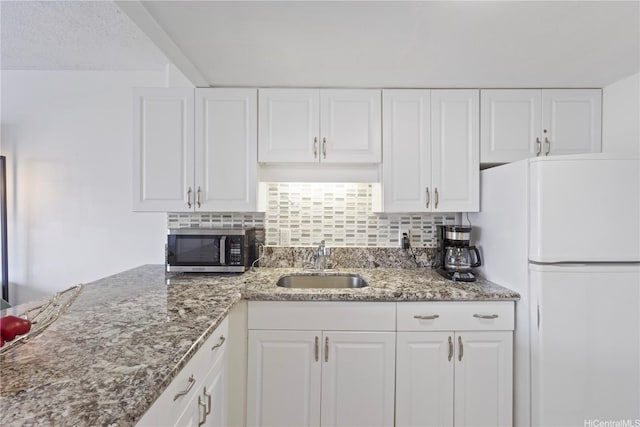 1777 Ala Moana Blvd Unit 1517, Honolulu, HI 96815 - kitchen featuring freestanding refrigerator, stainless steel microwave, white cabinets, backsplash, and stone countertops