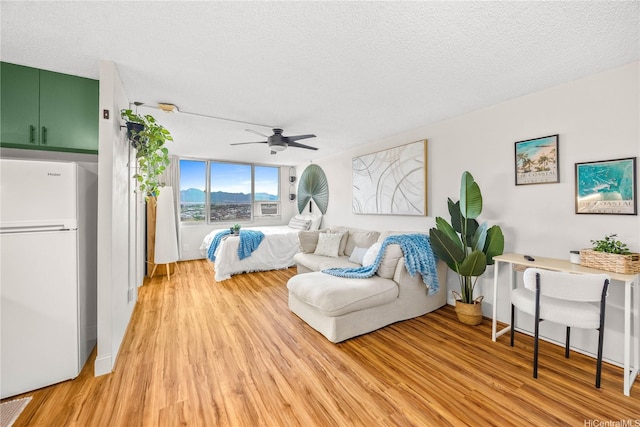 1060 Kamehameha Hwy Unit 2901A, Pearl City, HI 96782 - bedroom with freestanding refrigerator, light wood-style flooring, a textured ceiling, and ceiling fan