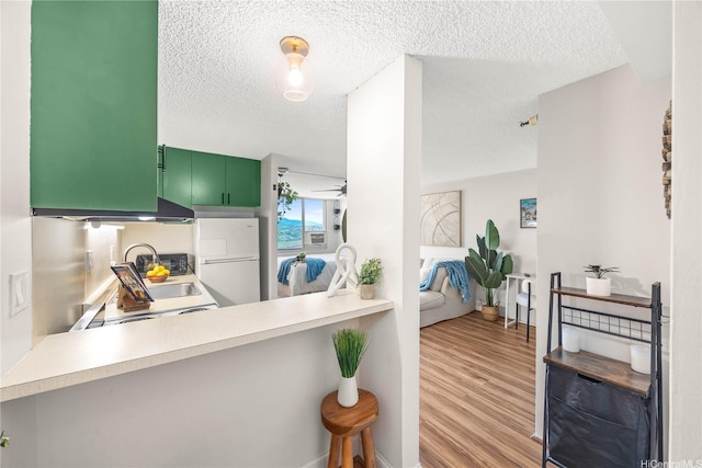 1060 Kamehameha Hwy Unit 2901A, Pearl City, HI 96782 - kitchen featuring freestanding refrigerator, a textured ceiling, wood finished floors, light countertops, and a peninsula
