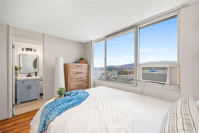 1060 Kamehameha Hwy Unit 2901A, Pearl City, HI 96782 - bedroom with wood finished floors, a textured ceiling, connected bathroom, a mountain view, and a sink