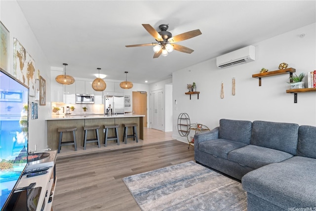 629 Keeaumoku St Unit 2505, Honolulu, HI 96814 - living area featuring an AC wall unit, a ceiling fan, and light wood-style floors