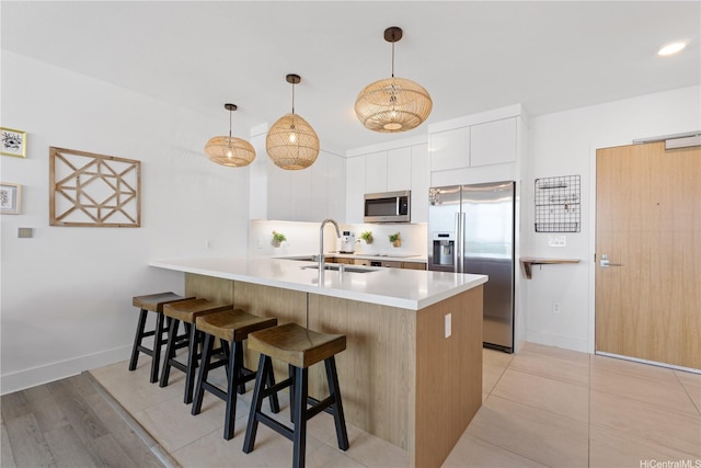 629 Keeaumoku St Unit 2505, Honolulu, HI 96814 - kitchen featuring appliances with stainless steel finishes, a peninsula, modern cabinets, a kitchen bar, and light countertops