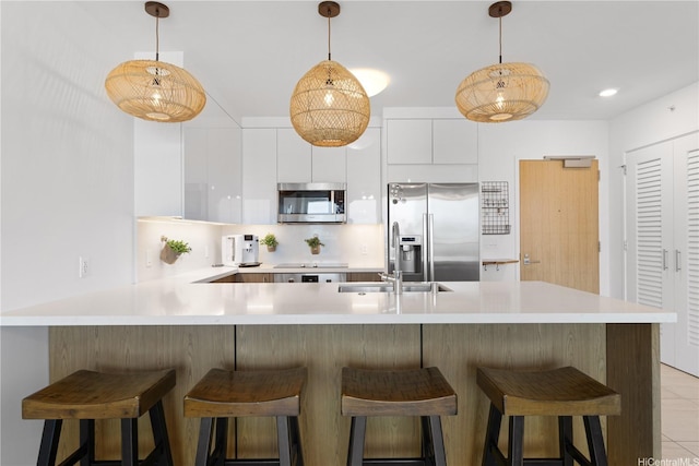 629 Keeaumoku St Unit 2505, Honolulu, HI 96814 - kitchen featuring appliances with stainless steel finishes, modern cabinets, light countertops, a peninsula, and white cabinetry