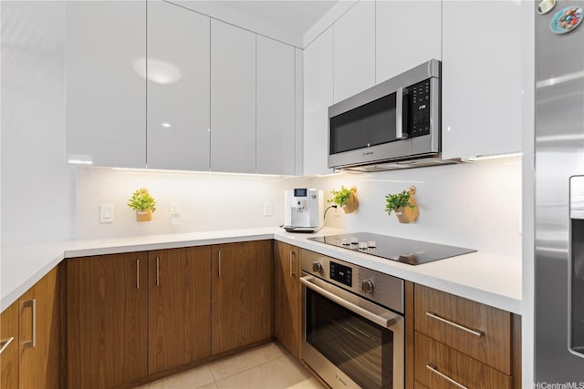 629 Keeaumoku St Unit 2505, Honolulu, HI 96814 - kitchen with appliances with stainless steel finishes, white cabinetry, modern cabinets, light countertops, and brown cabinetry