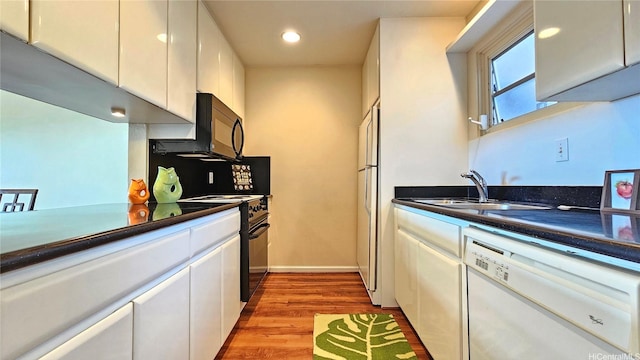 98-1451 Kaahumanu St Unit B218, Aiea, HI 96701 - kitchen with black appliances, white cabinets, dark countertops, light wood-style floors, and recessed lighting
