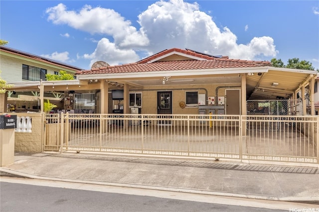 94-1090 Kuhaulua St, Waipahu, HI 96797 - view of front facade with a fenced front yard, a tile roof, and a carport