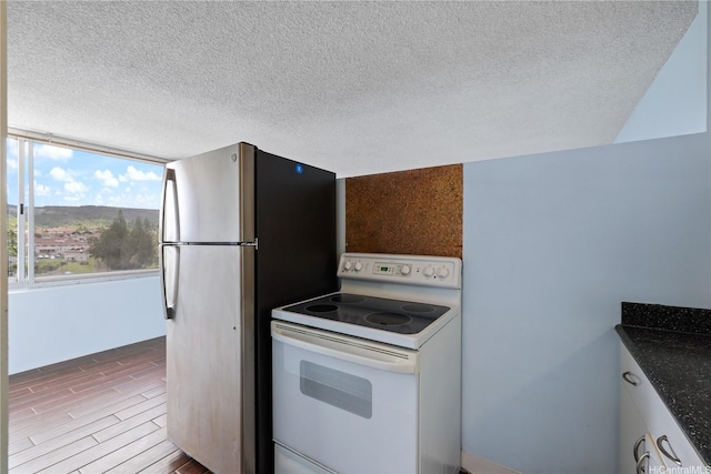 98-288 Kaonohi St Unit 1107, Aiea, HI 96701 - kitchen featuring electric range, wood finished floors, freestanding refrigerator, a textured ceiling, and dark countertops