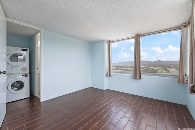98-288 Kaonohi St Unit 1107, Aiea, HI 96701 - laundry area featuring stacked washer / drying machine, dark wood-style floors, a textured ceiling, and a mountain view