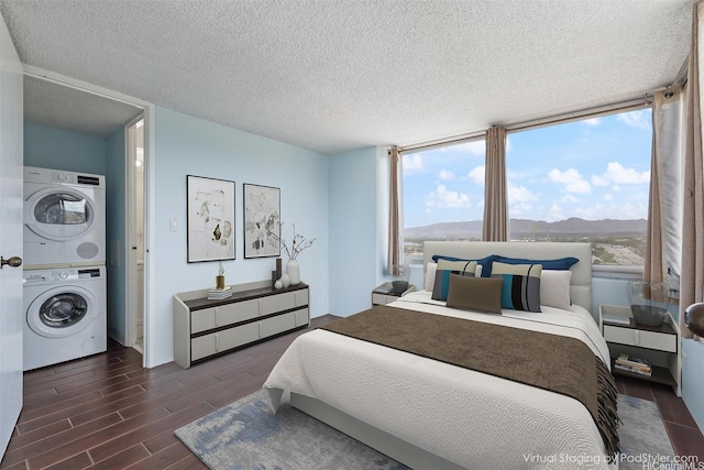98-288 Kaonohi St Unit 1107, Aiea, HI 96701 - bedroom with stacked washer / drying machine, wood finished floors, a textured ceiling, and a mountain view