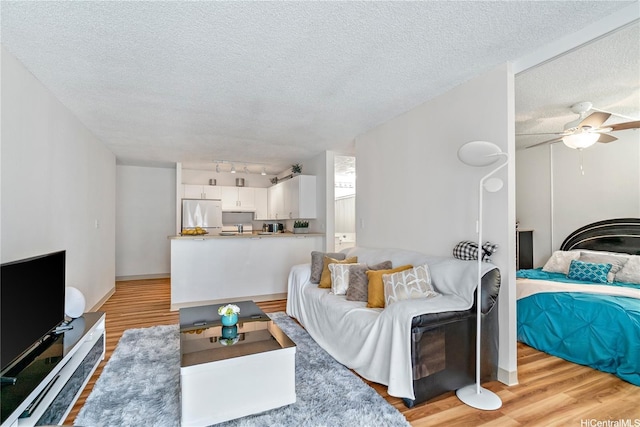 2452 Tusitala St Unit 705, Honolulu, HI 96815 - living room featuring light wood-type flooring, a textured ceiling, and a ceiling fan