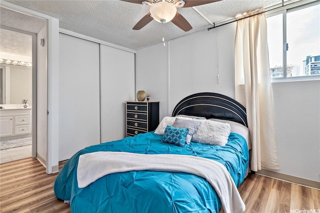 2452 Tusitala St Unit 705, Honolulu, HI 96815 - bedroom with wood finished floors, a ceiling fan, ensuite bath, a textured ceiling, and a closet