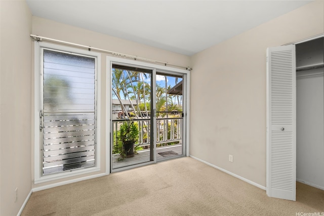 609 Koko Isle Cir Unit 1205, Honolulu, HI 96825 - unfurnished bedroom with access to outside, carpet flooring, and baseboards