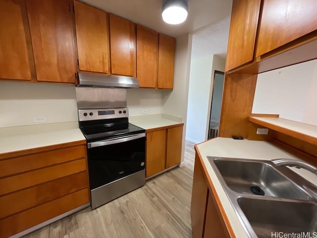1441 Piikoi St Unit 402, Honolulu, HI 96822 - kitchen with stainless steel range with electric cooktop, under cabinet range hood, a sink, light wood-type flooring, and light countertops