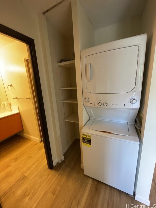 1441 Piikoi St Unit 402, Honolulu, HI 96822 - clothes washing area featuring estacked washer and dryer, light wood-type flooring, and baseboards