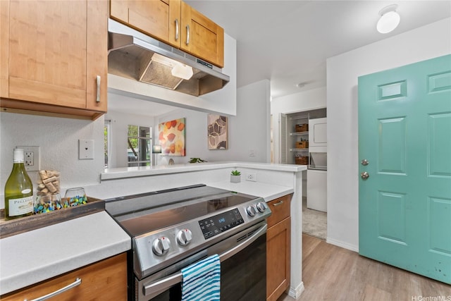 95-798 Wikao St Unit S104, Mililani, HI 96789 - kitchen with stainless steel range with electric cooktop, under cabinet range hood, light wood-type flooring, light countertops, and a peninsula