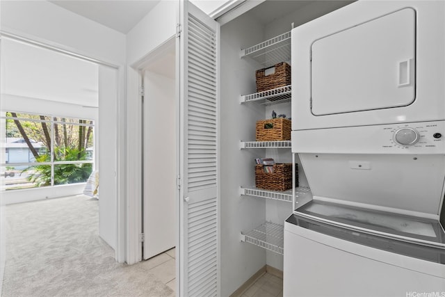 95-798 Wikao St Unit S104, Mililani, HI 96789 - laundry area featuring stacked washer and clothes dryer, baseboards, and light colored carpet