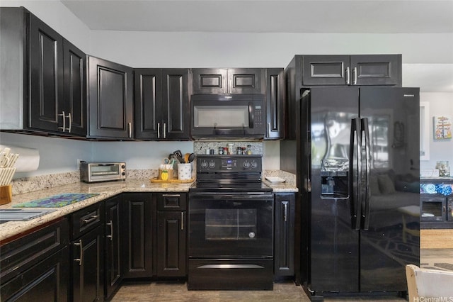 53-440 Kamehameha Hwy Unit 8, Hauula, HI 96717 - kitchen featuring black appliances, dark cabinets, and light stone counters