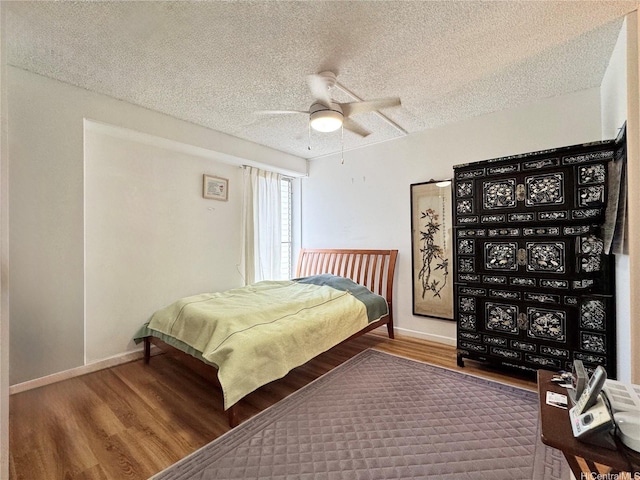 1655 Makaloa St Unit 705, Honolulu, HI 96814 - bedroom featuring wood finished floors, a textured ceiling, baseboards, and ceiling fan
