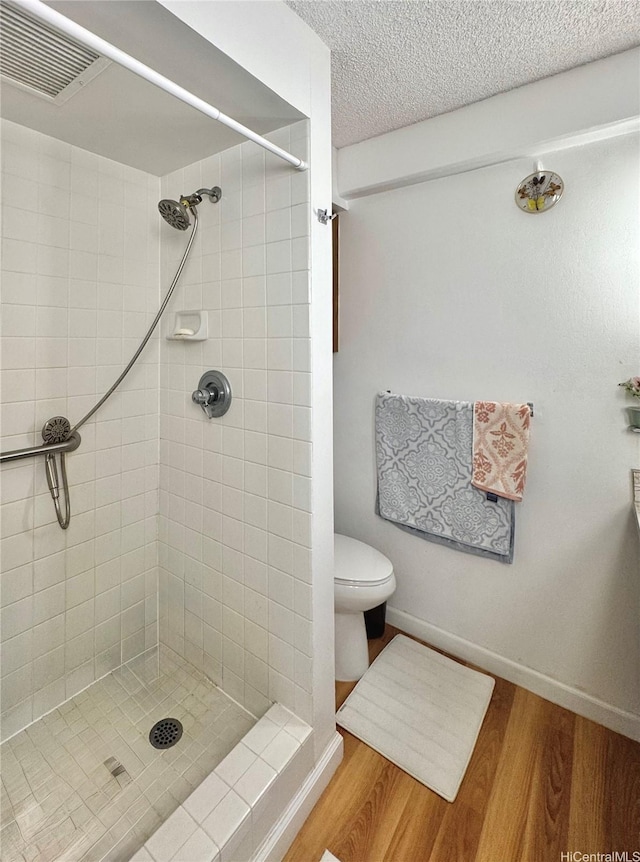 1655 Makaloa St Unit 705, Honolulu, HI 96814 - full bath with tiled shower, wood finished floors, toilet, a textured ceiling, and baseboards